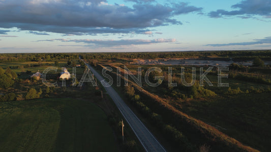 Golden Hour Aerial Lift Over Leachs Road With Farm Fields and Sand Pit