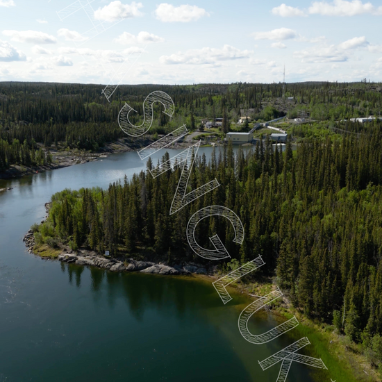 Bluefish Hydroelectric Facility aerial view over Prosperous Lake shoreline, Northwest Territories vertical drone footage