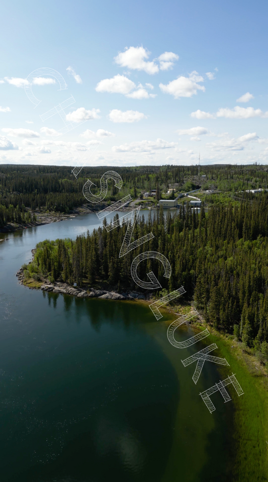 Bluefish Hydroelectric Facility aerial view over Prosperous Lake shoreline, Northwest Territories vertical drone footage